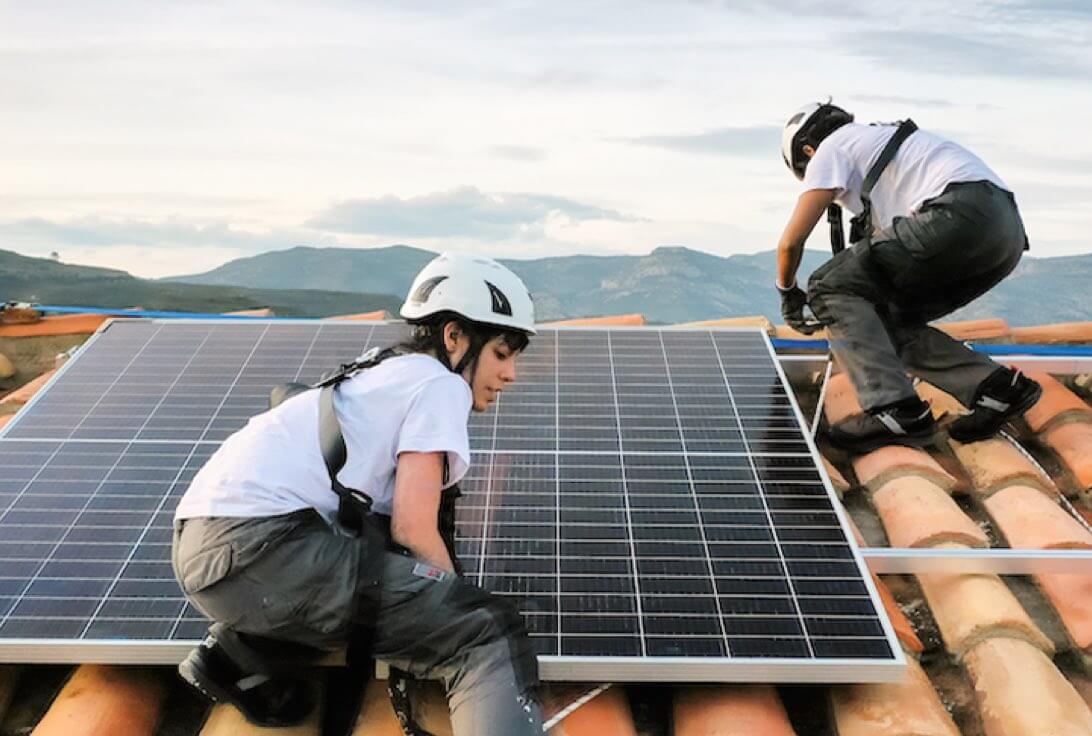 instaladores trabajando en tejado con placas solares en La Palma. Autoconsumo colectivo